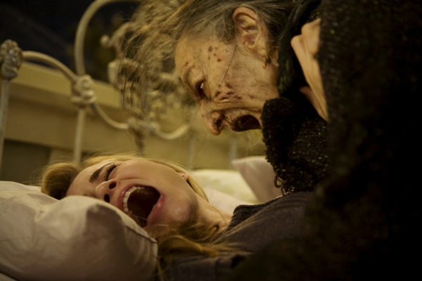 old angry woman looms over a younger scared woman