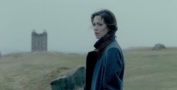 A woman stands on Hillside reflecting or searching for something