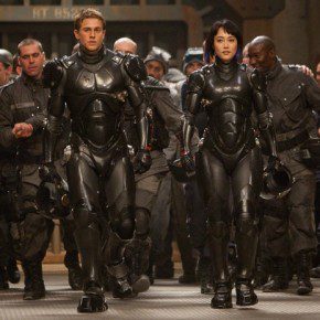 A group of people in strange suits walk towards the Jaegers in Pacific Rim