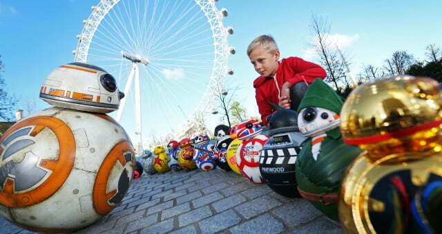 A small boy with BB-8 models from Star Wars: The Force Awakens.