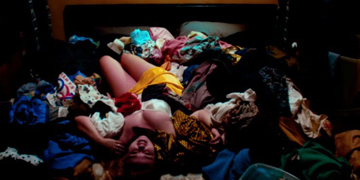semi naked woman lies on a bundle of clothes