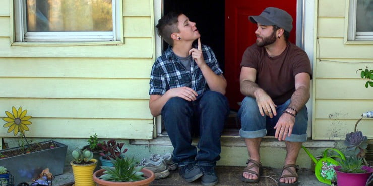 2 men sit on doorstep chatting in Real Boy