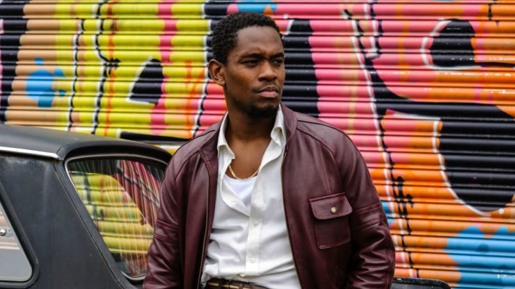 Young black man chills as he watches the world go by.