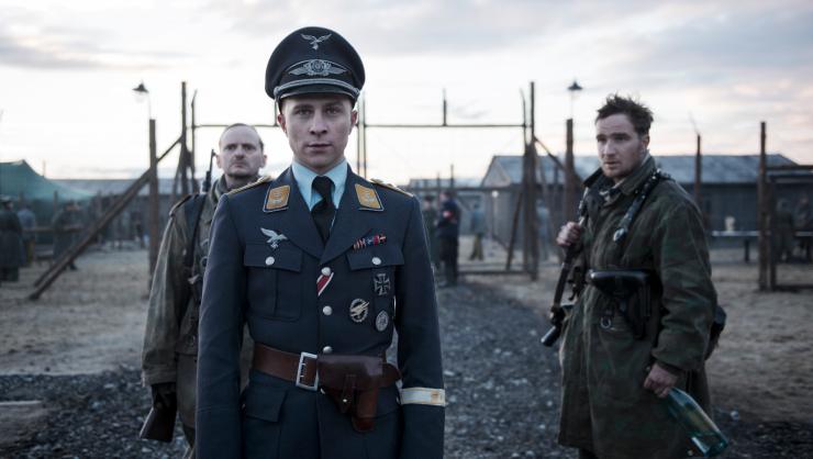 A man dressed as German Nazi soldier surrounded by Soldiers in The Captain.