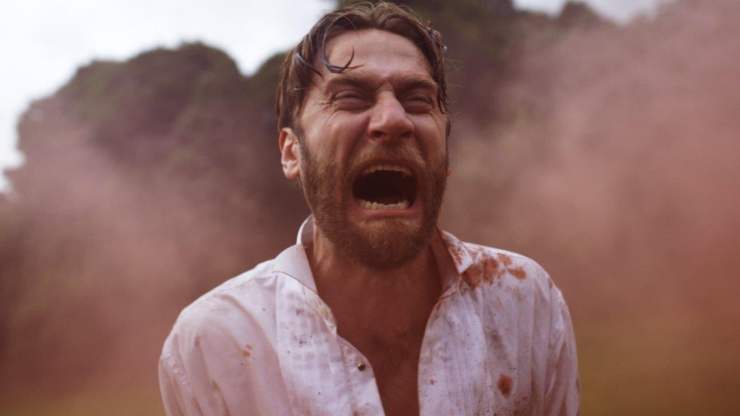 a man in a white bloodied shirt screams in Automata