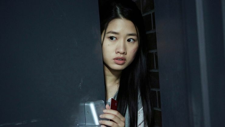 A young Asian student peek's out the door in Level 16