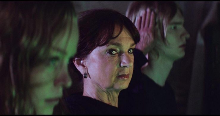An older woman stares out between younger women in The Black Circle