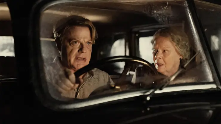A middle aged man and older woman drive in the dark in Six Minutes To Midnight
