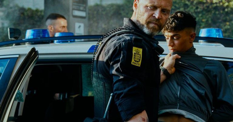 Angry police officer grabs young man