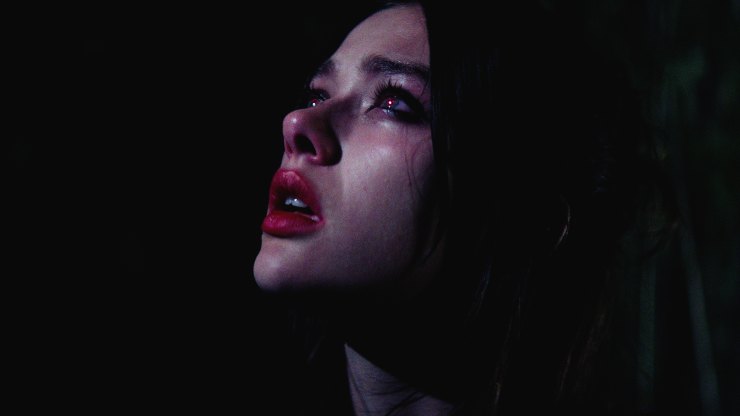 A woman looks confused in a dark room
