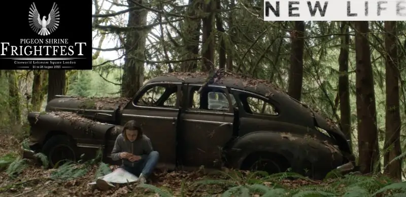 A woman sits in a frorest in front of a an old windowless car in New Life