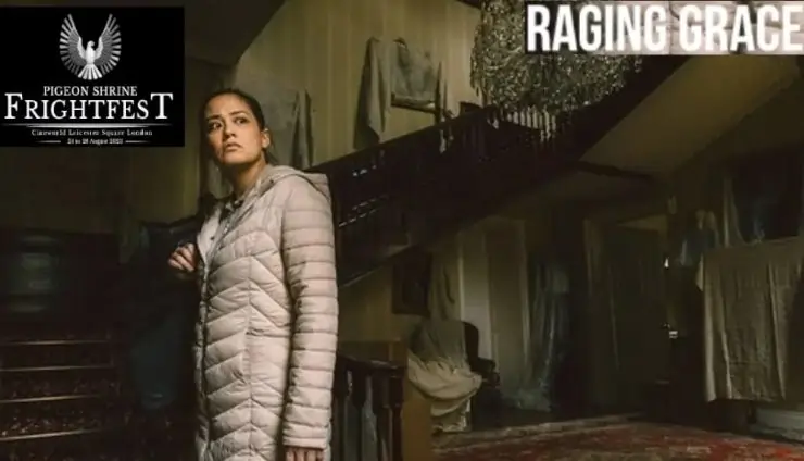 An Asian woman in grey jacket stands in a dark building