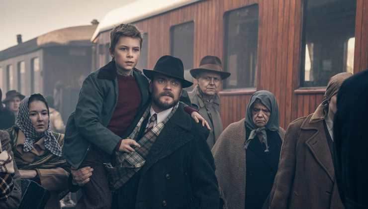 Aman carries a young boy off a train in WWII Drama Liberation