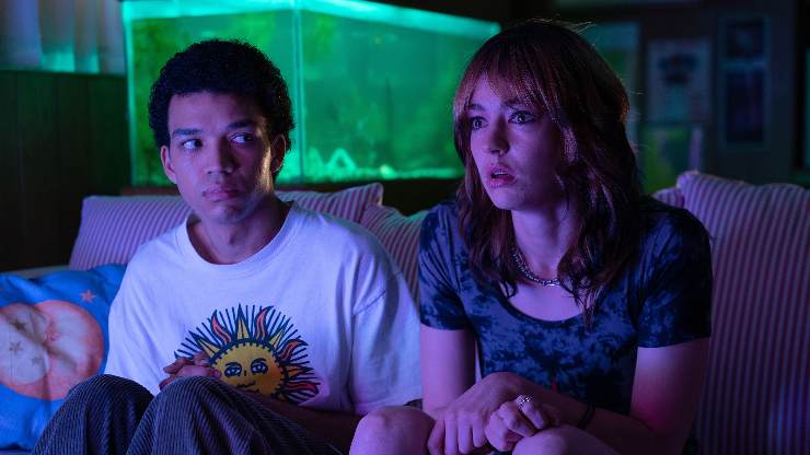 I Saw The TV Glow, a young man and woman sit and watch TV
