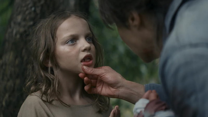 someone exams a young girls teeth 