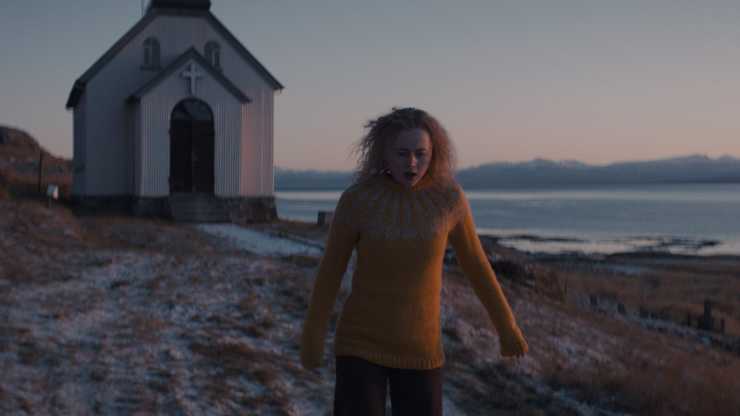 A woman with no jacket walks away from a small church in thriller Cold.