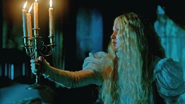 A long haired blonde woman holds a candle in Guillermo Del Toro's Crimson Peak 4K uhd