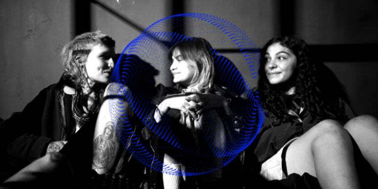 3 women sit around in Gasoline Rainbow