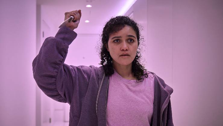 woman in corridor holding a knife