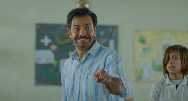 Happy man speaks to children in school