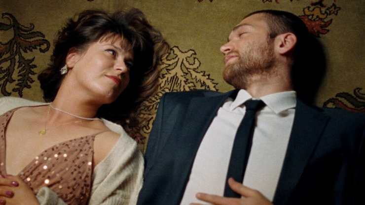 man and woman lie down staring at each other