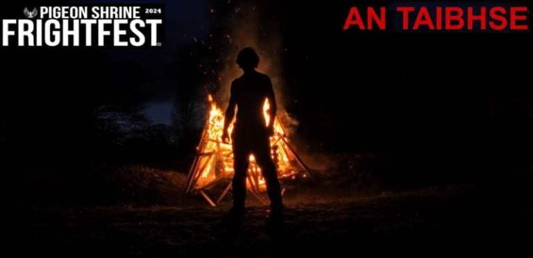 An unknown man standing next to a fire
