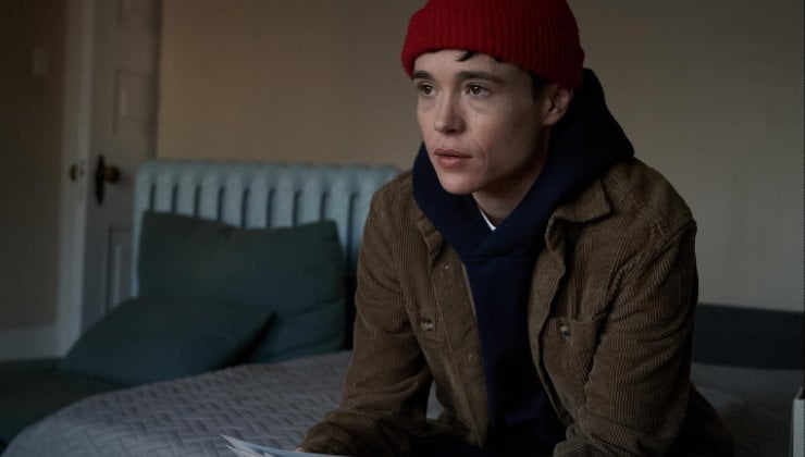 Trans man sits on the bed (Elliott Page)