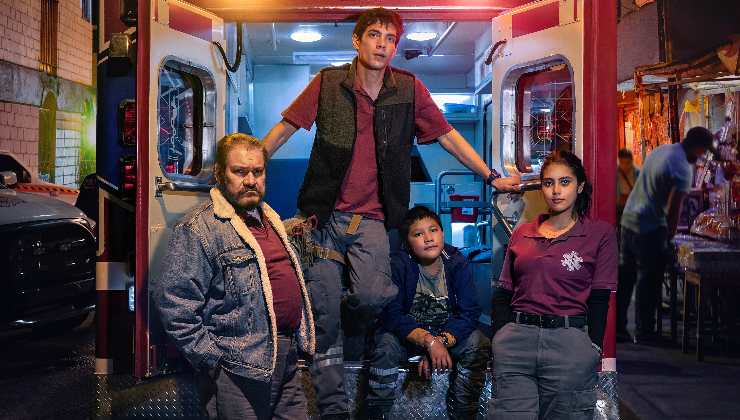 A family pose around an ambulance