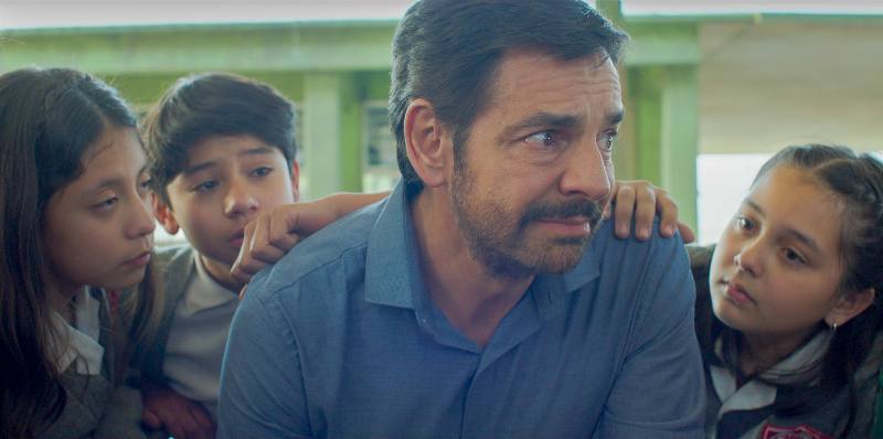 A school teacher comforted by his students