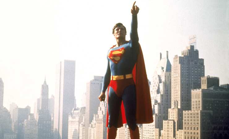 Superman stands tall pointing to something