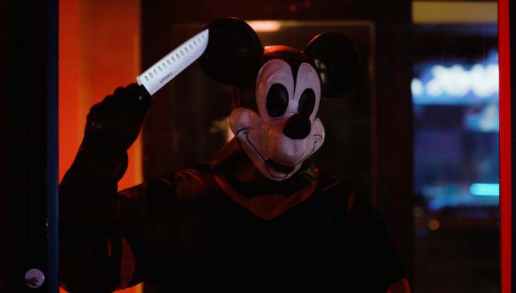Someone with a bad Mickey Mouse Mask with knife