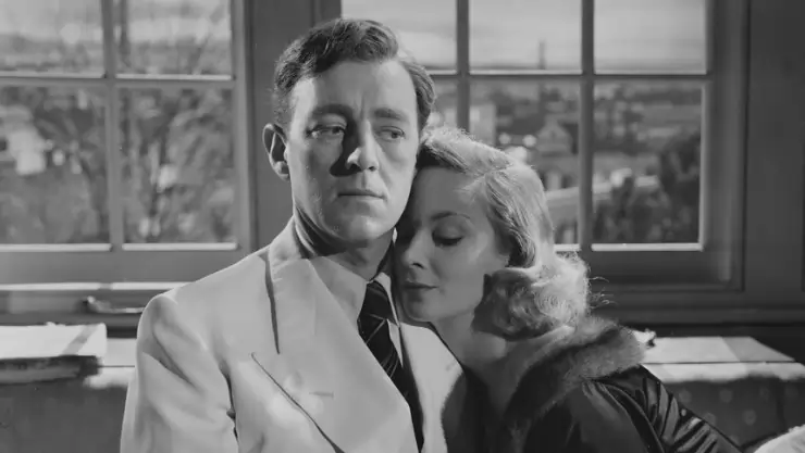 A woman rests her head on a man's shoulder