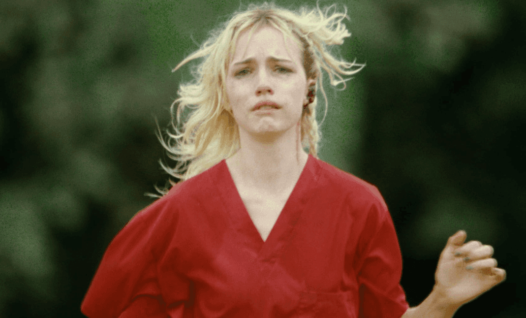 Woman in a red gown runs in fear in strange darling