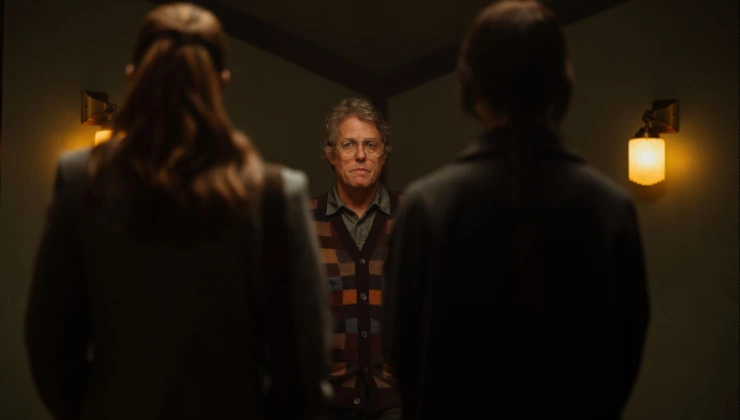 A man stands in front of two women in Heretic