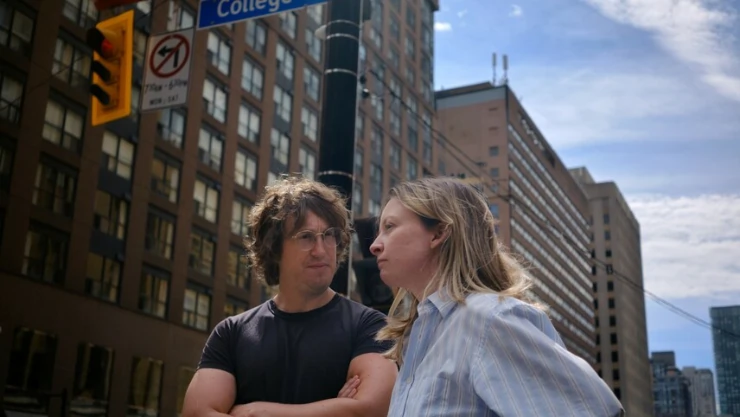 a man and woman stand together in a street in Matt And Mara