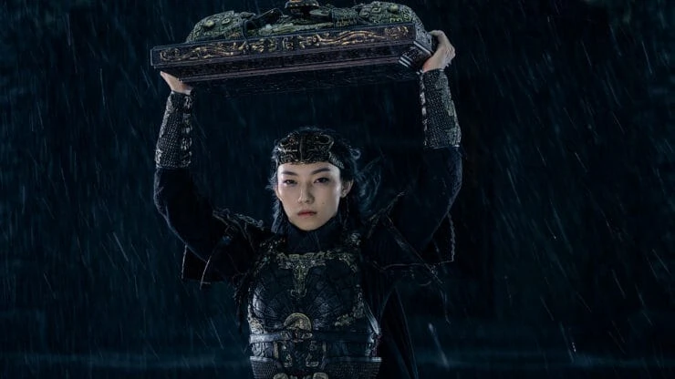 A Female warrior carries something over her head in Creation Of The Gods 2