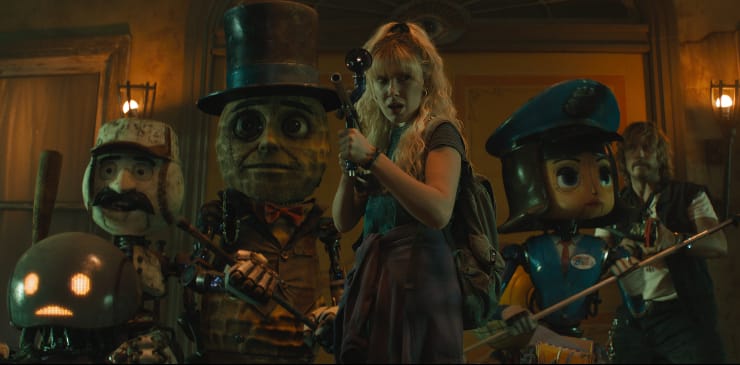 A girl stands side by side with robots in The Electric State