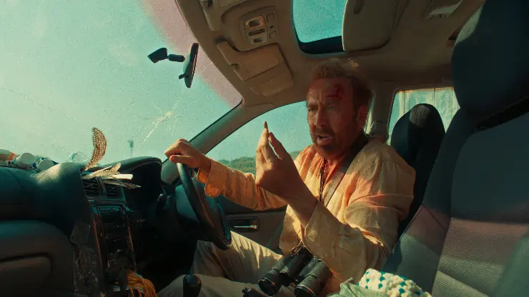 A man in a car stares at a bullet (nicolas cage ) in The Surfer.