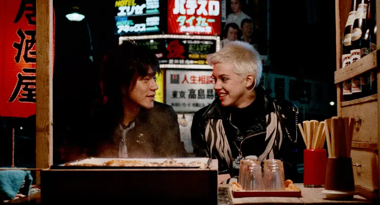 Japanese man and American woman sit with each other in Tokyo Pop