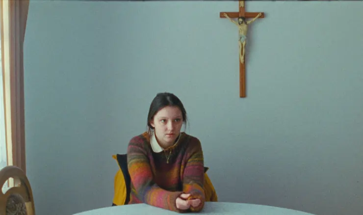 A young girl sits at the table in I Saw the face of the devil (2023)