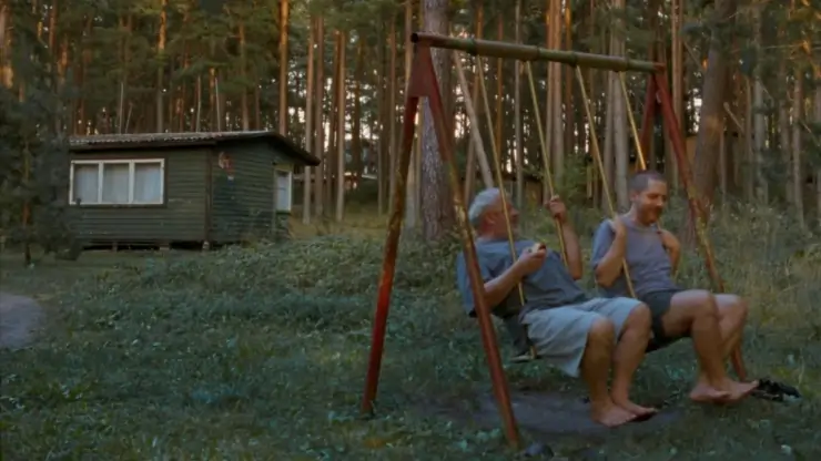 2 men in swings in The Visitor