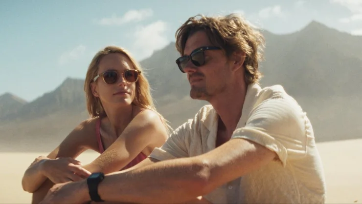 A man and woman sit on a beach in Islands