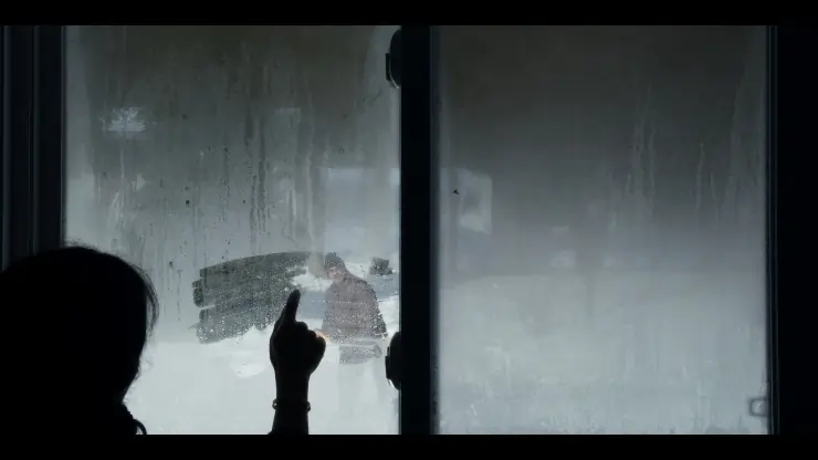 Woman wipes her window in The Mortician