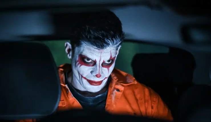 psychotic man in clownpaint sits in Helloween