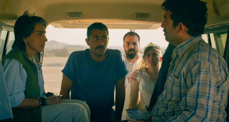 People standing outside a van talking to people sitting in the van. Jafar Panahi's It Was An Accident coming to MUBI