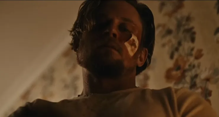A bruised man looks down on something (Billy Magnussen) in Violent Ends