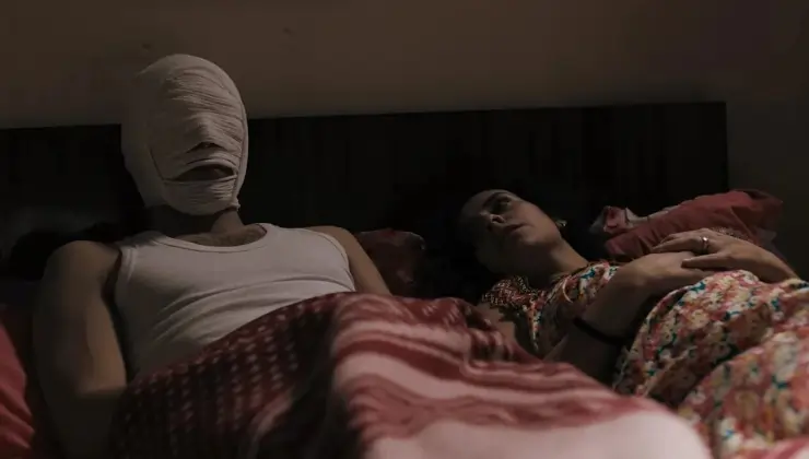 Venice 2025 Roqia review, man lies in bed face bandaged