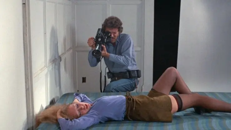 A woman lies seductively on a bed as a man films her in Hollywood 90028 (1973)
