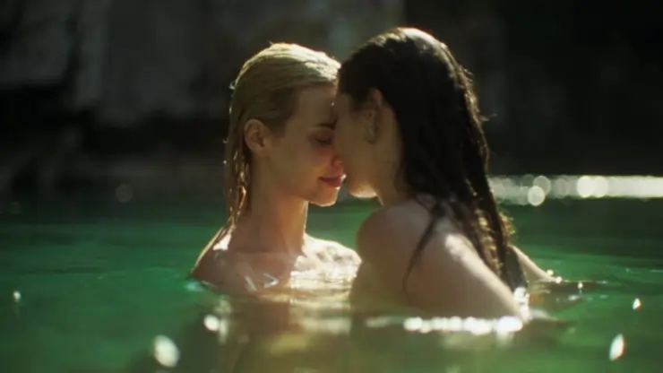 2 women lovingly embrace in water in Bearcave