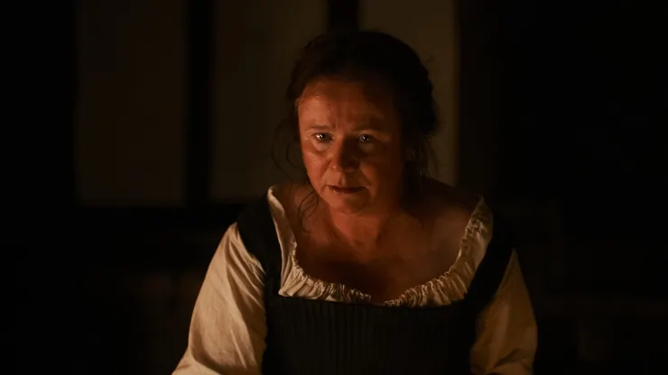 An older woman (Emily Watson) looks on in concern in Hamnet.